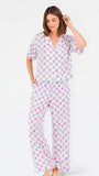 Woman wearing a purple floral pajama set on a white background