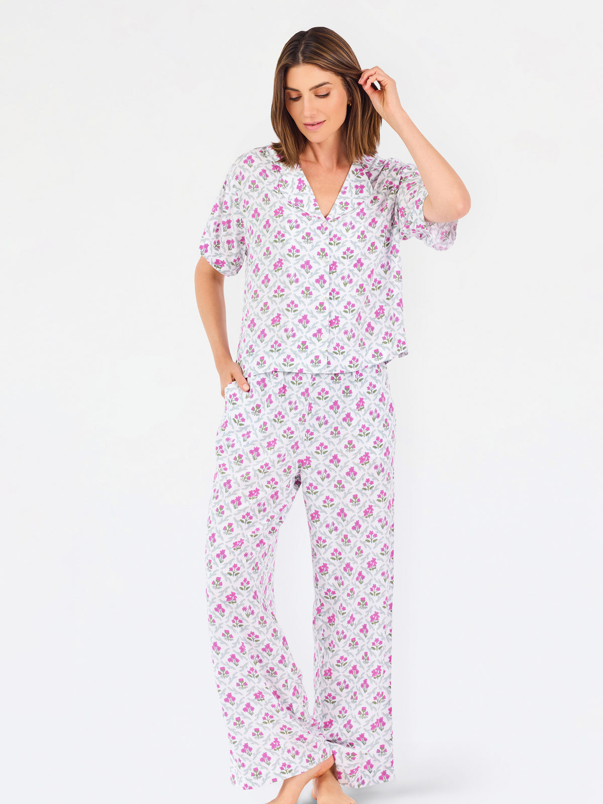 Woman wearing a purple floral pajama set on a white background