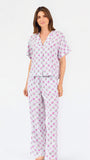 Woman wearing a purple floral pajama set on a white background
