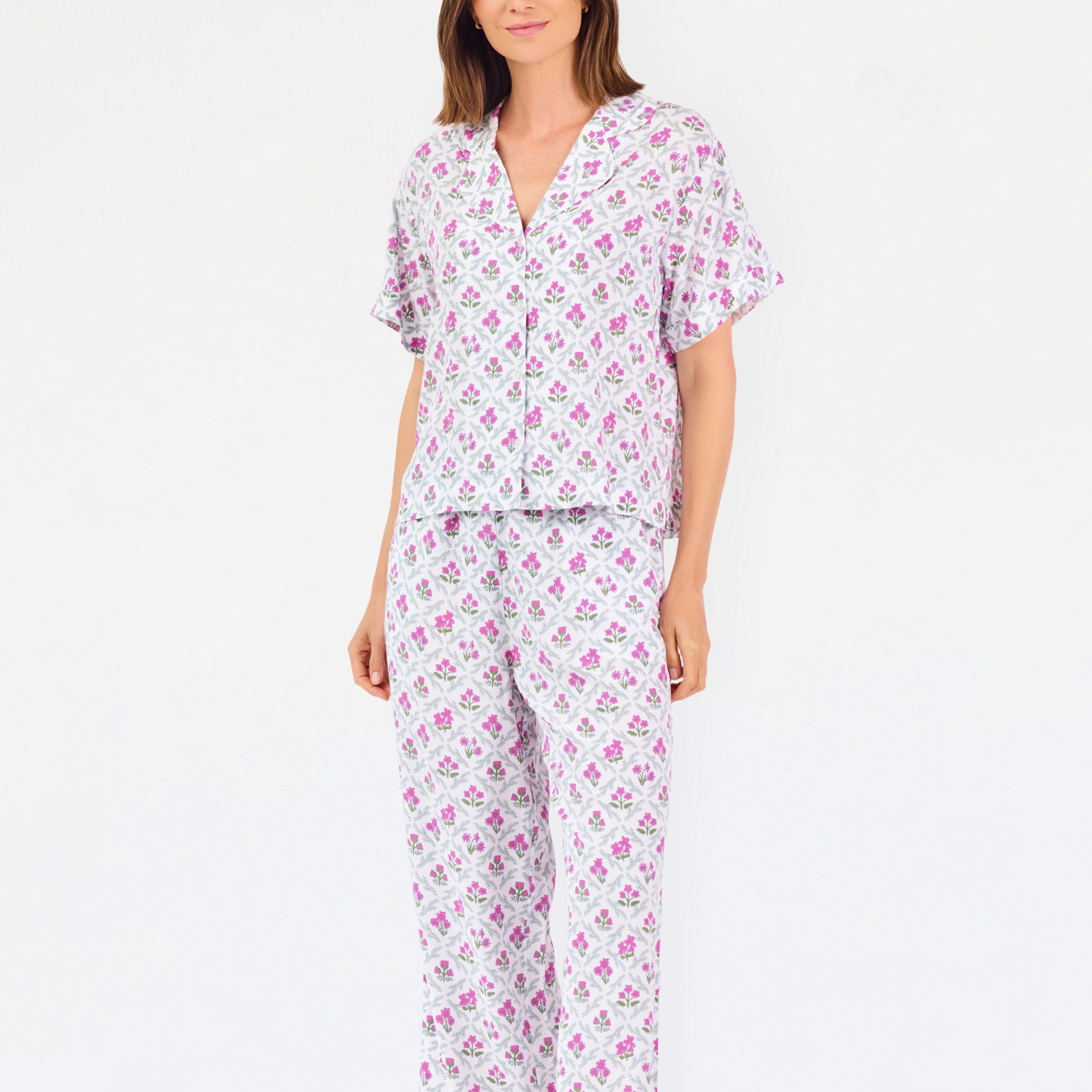 Woman wearing a purple floral pajama set on a white background