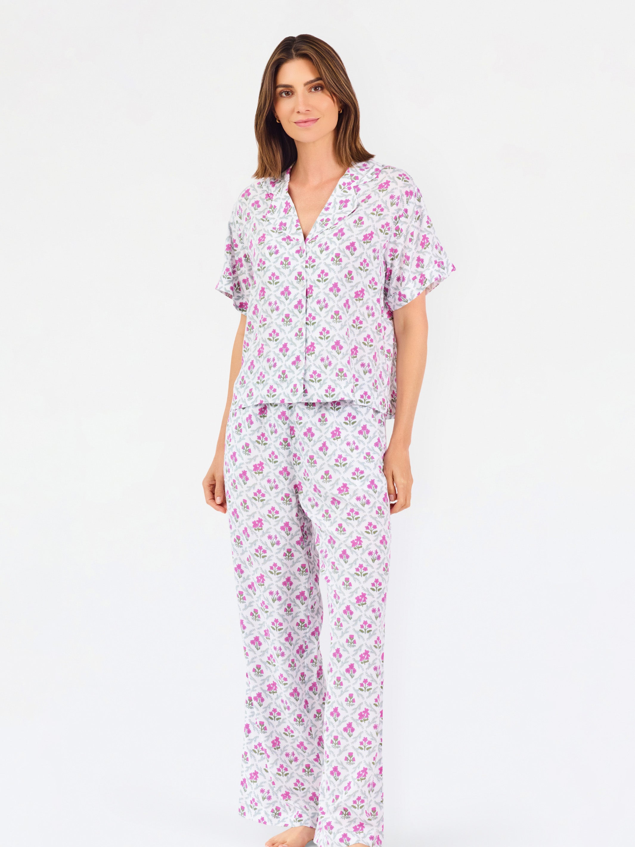 Woman wearing a purple floral pajama set on a white background