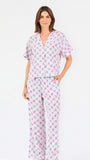Woman wearing a purple floral pajama set on a white background