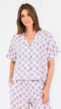 Woman wearing a purple floral pajama set on a white background