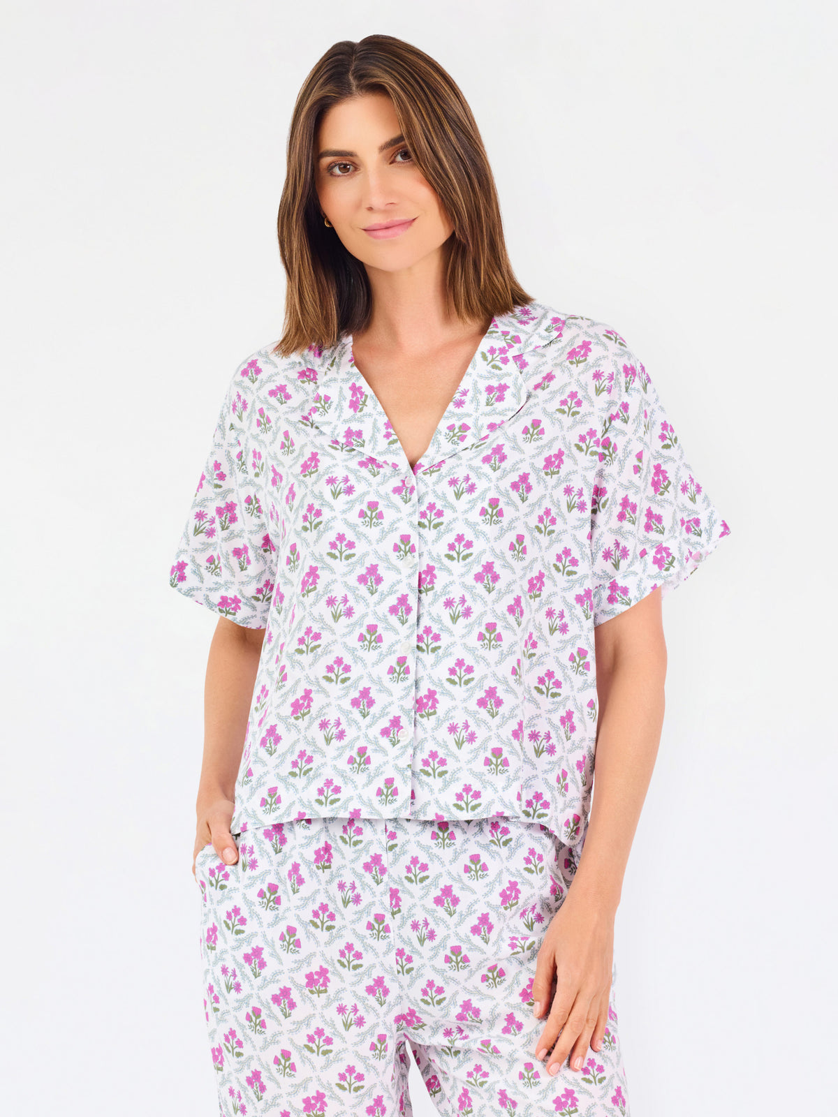 Woman wearing a purple floral pajama set on a white background