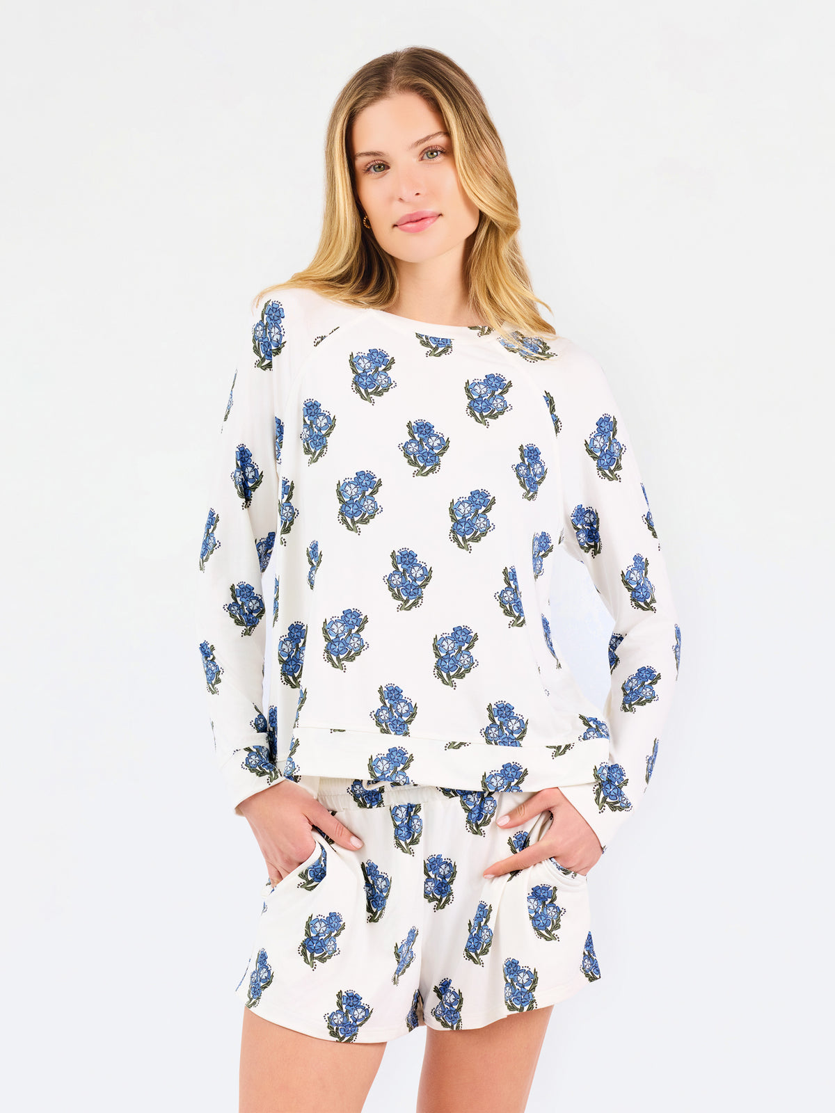Woman wearing white pajamas with blue floral patterns on a white background