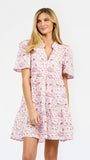 A woman modeling a short-sleeve red toile football print dress against a plain white studio background.