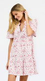 A woman wearing a short-sleeve pink and white floral print dress, posing against a solid white studio background.