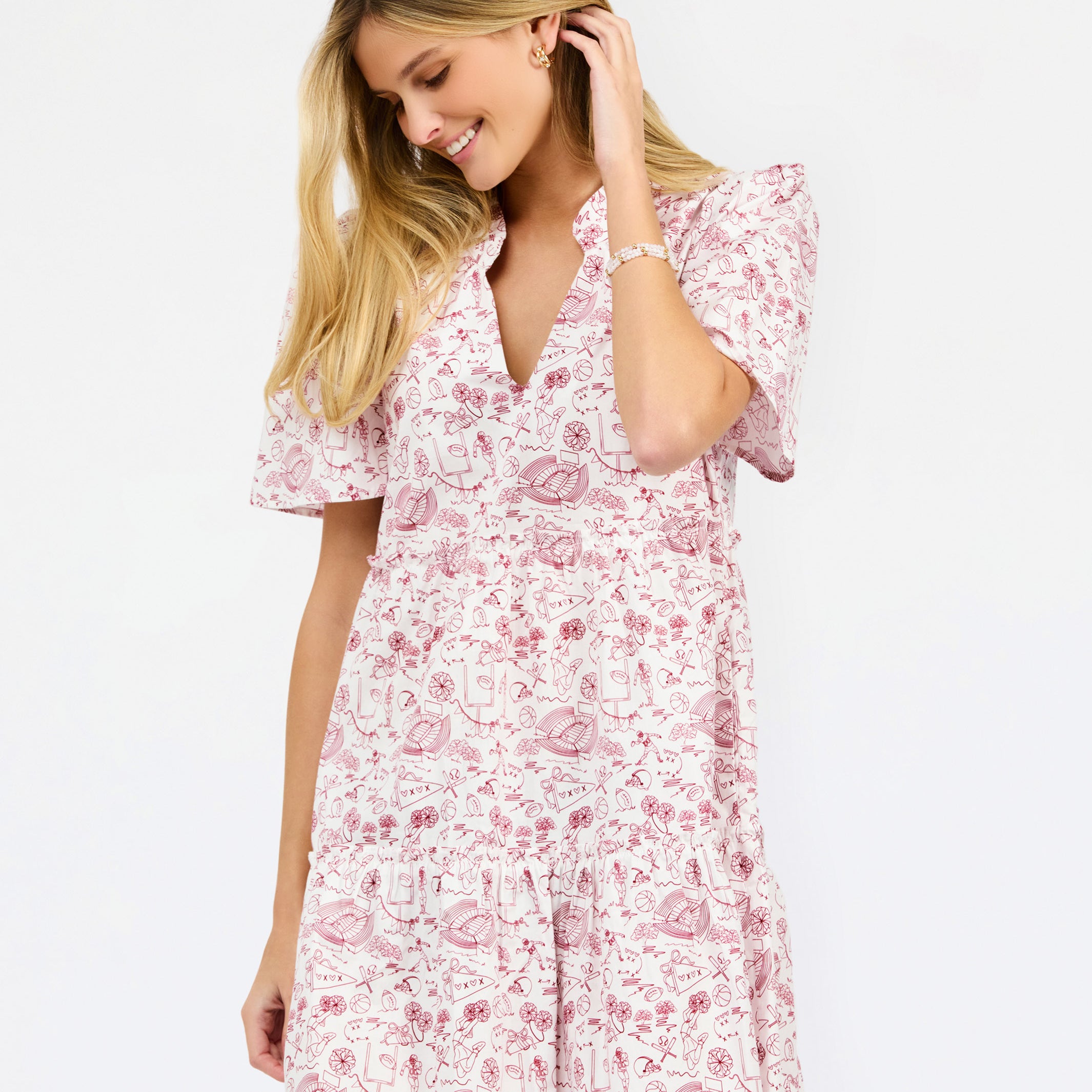 A woman wearing a short-sleeve pink and white floral print dress, posing against a solid white studio background.