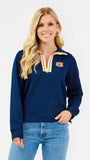A blonde woman wearing a navy blue quarter-zip sweatshirt with a white and gold striped collar and an embroidered Auburn Tigers logo on the chest, paired with blue jeans, against a plain white studio background.