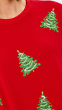 A close-up of a bright red crewneck sweatshirt featuring embroidered green Christmas trees with gold stars and white garlands.
