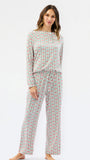 A woman modeling a matching long-sleeve top and wide-leg pants set with a vertical red and green pattern on a white background, photographed against a plain white studio backdrop.