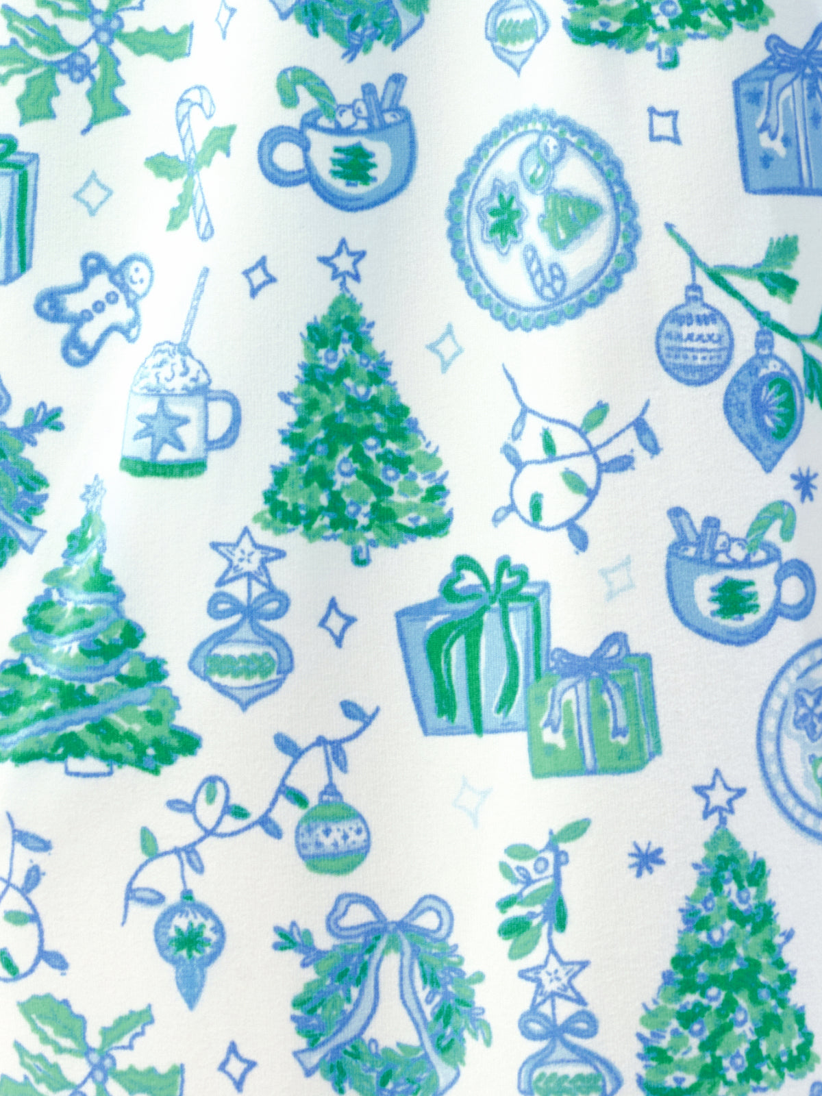 A close-up of a fabric pattern featuring Christmas motifs like evergreen trees, ornaments, gifts, candy canes, and hot cocoa cups in blue and green on an off-white background.