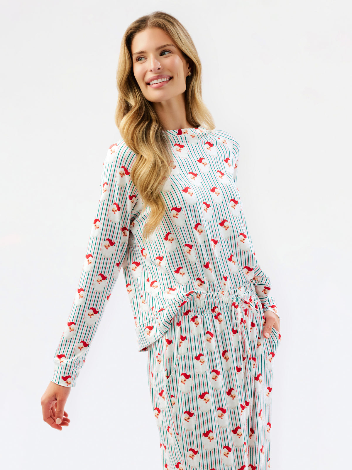 A woman modeling a matching long-sleeve top and pants set with a white base, thin vertical blue stripes, and a red and blue bird pattern, against a plain white studio background.
