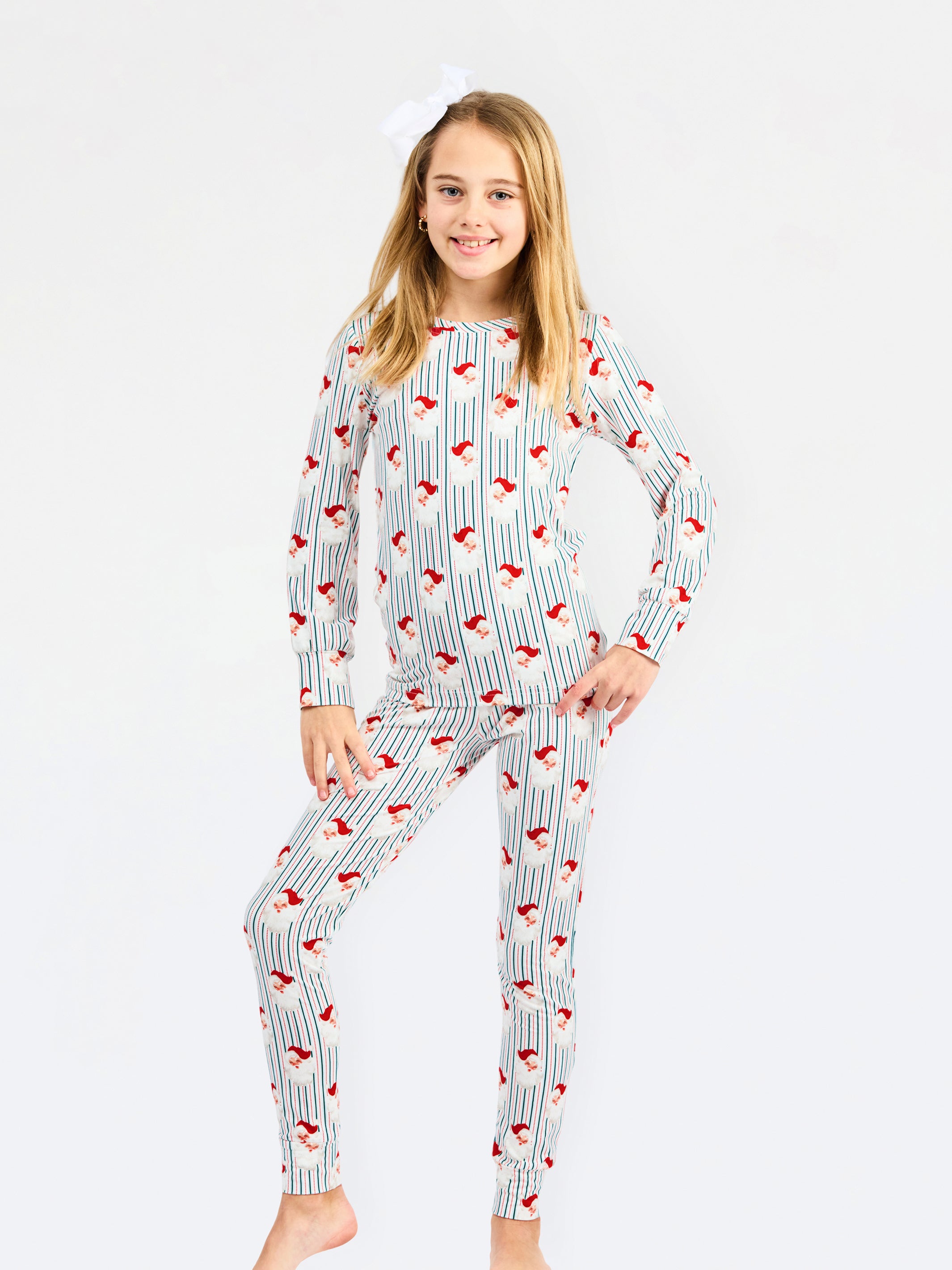 A young girl modeling a long-sleeve pajama set with a white base, vertical blue stripes, and red fox prints, set against a plain white background.