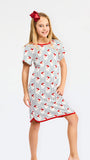 A young girl modeling a short-sleeve nightgown with a white base, red trim, and a repeating pattern of red birds on thin vertical blue stripes, set against a plain white studio background.