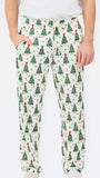 A person wearing white drawstring pants with an all-over green Christmas tree print, paired with a white top and white socks, against a plain white background.