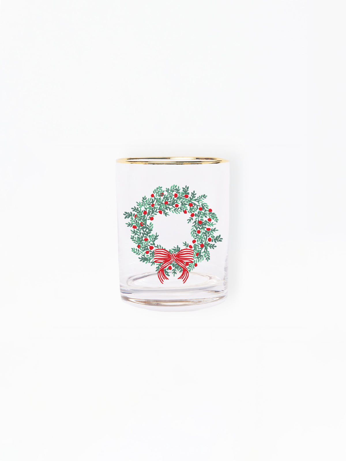 A clear glass shot glass featuring a printed green holly wreath with red berries and a red bow, finished with a gold rim, set against a plain white background.