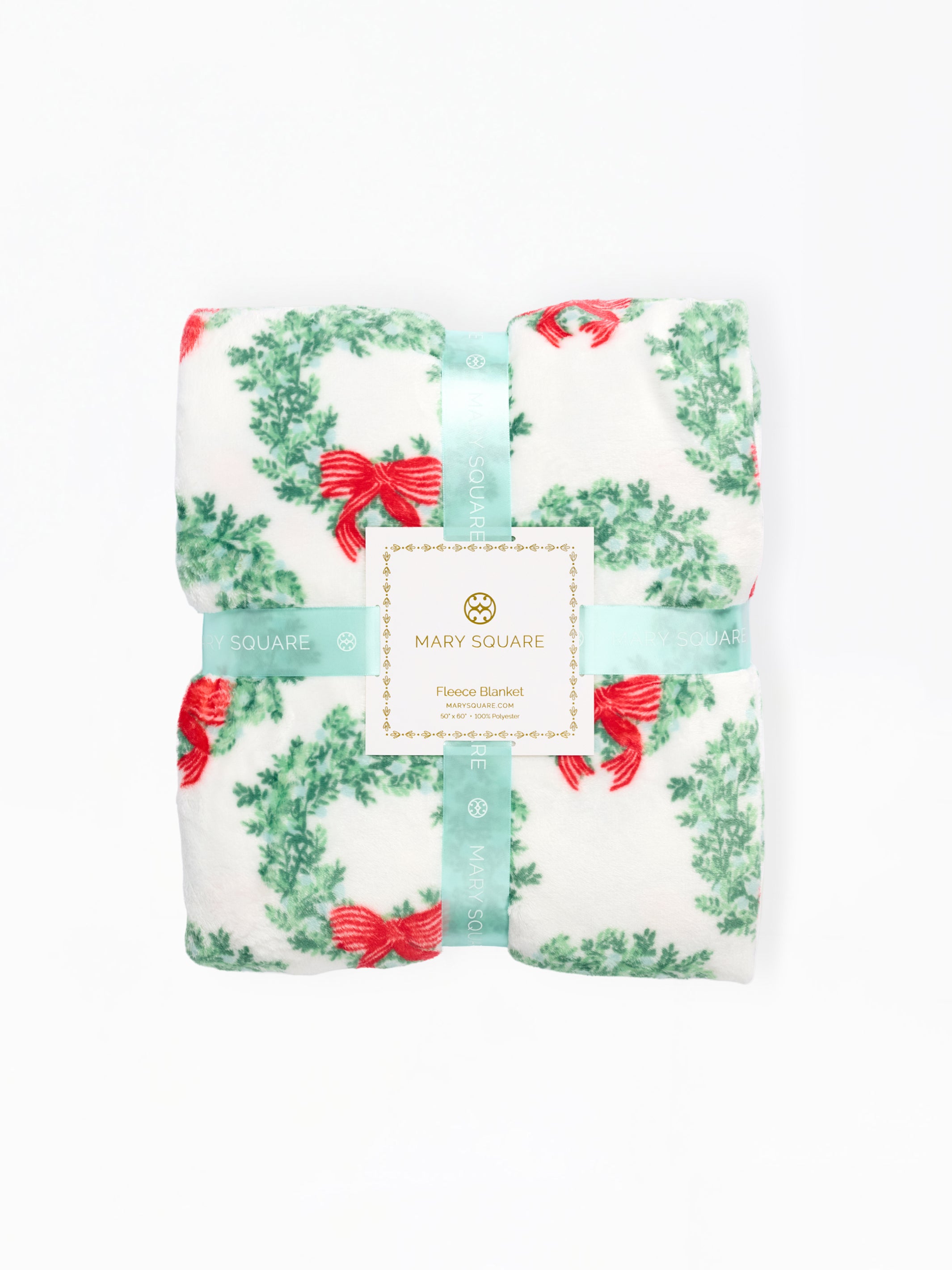 A folded Mary Square floral blanket with a green wreath and red bow pattern, wrapped in a light blue ribbon with a white brand label.