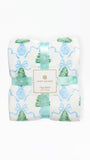 A folded Mary Square flannel blanket with a festive holiday print, featuring green pine trees, blue ornaments, and light blue wavy lines on a white background, wrapped in a matching mint green ribbon with a central brand label.