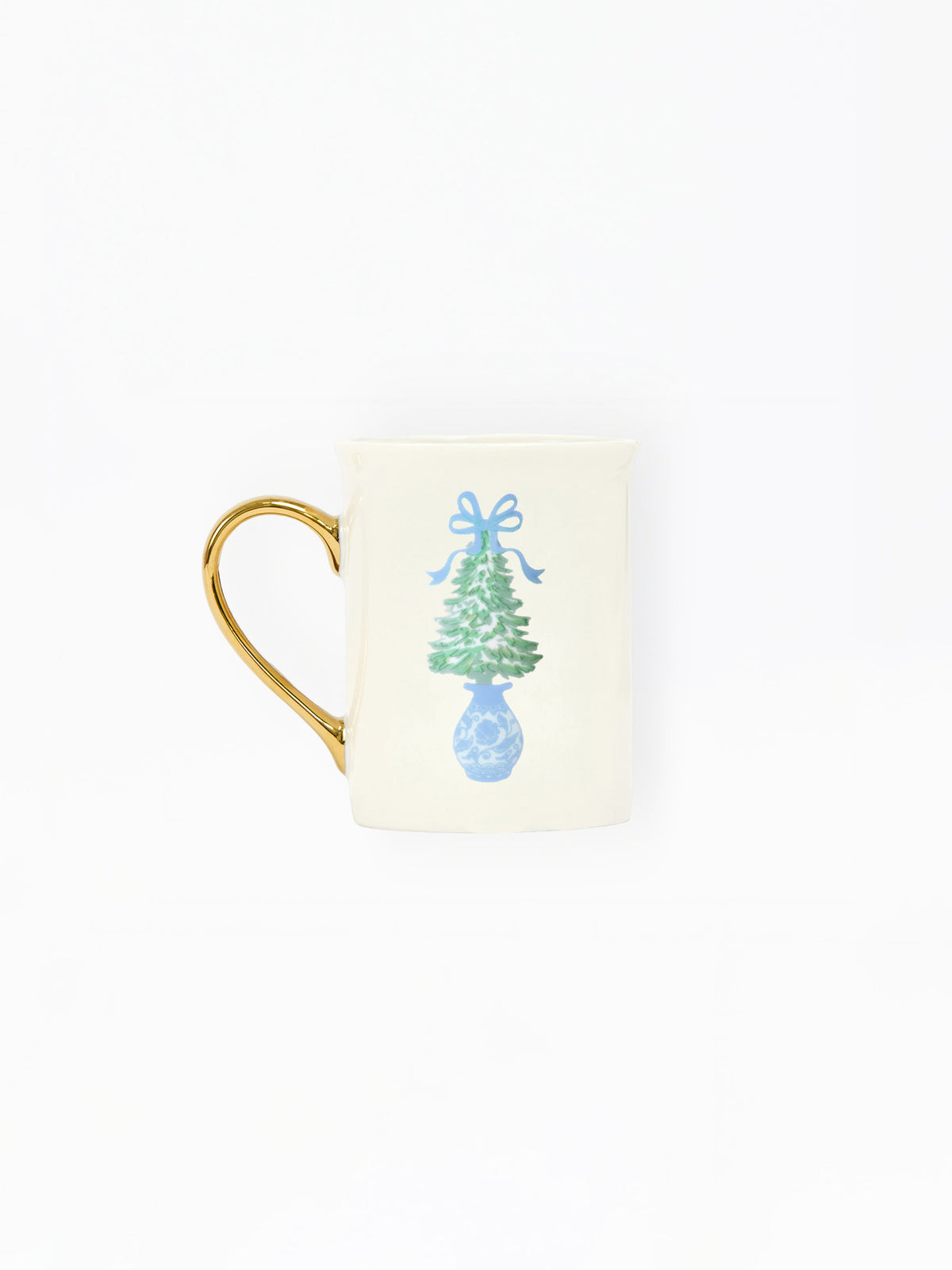 An off-white ceramic mug with a gold handle, featuring a printed illustration of a green Christmas tree in a blue vase with a blue bow on the front.
