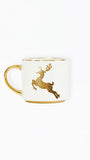 A white ceramic mug with a gold handle, gold rim, and a gold metallic leaping deer graphic on the side, set against a plain white background.