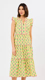 Woman wearing a yellow dress with pink floral pattern on a white background