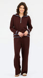 A woman modeling a matching two-piece lounge set in deep burgundy, featuring a quarter-zip long-sleeve top with light blue and white striped trim, and matching wide-leg pants.