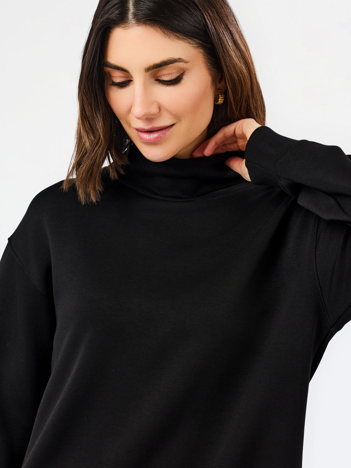 A woman wearing a black long-sleeve turtleneck top, shown from the chest up against a plain light background.