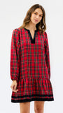 A woman modeling a red tartan plaid nightgown with black trim on a plain white studio background.
