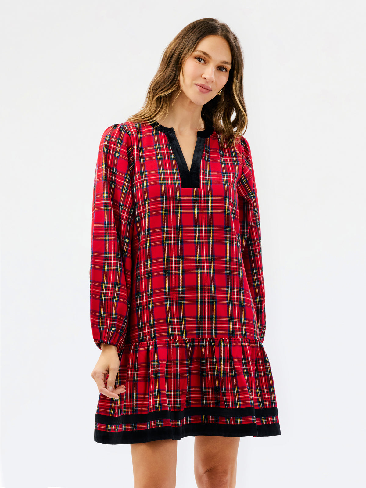 A woman modeling a red tartan plaid nightgown with black trim on a plain white studio background.