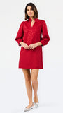 A woman modeling a red textured mini dress with three-quarter sleeves and a split neckline, paired with silver pointed-toe heels, against a plain white studio background.
