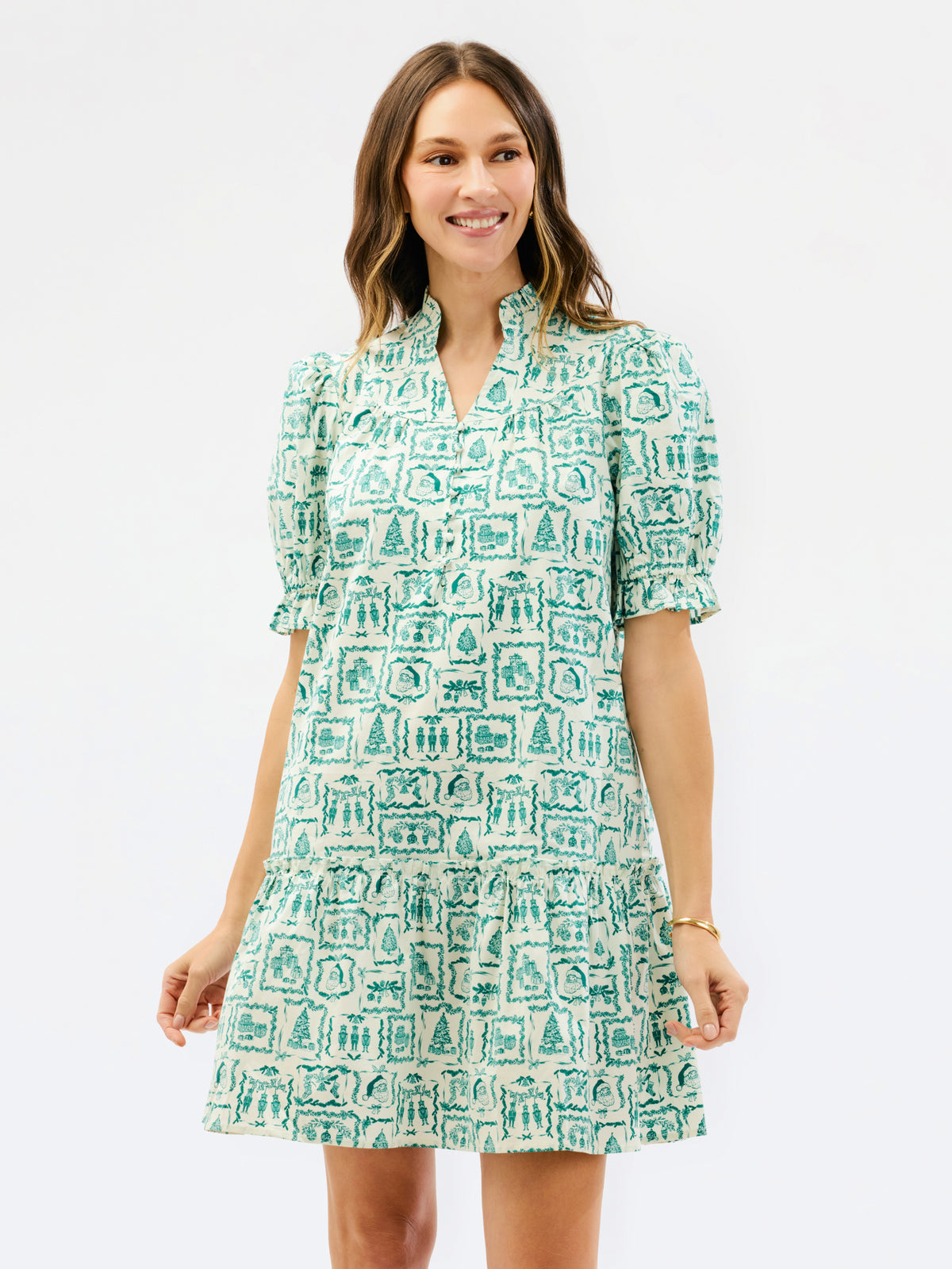 A woman modeling a short puff-sleeve dress with a green and white architectural line-art print, set against a plain white studio background.