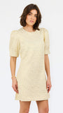 A woman modeling a short-sleeved cream lace dress with puff sleeves and a round neckline, set against a plain white studio background.