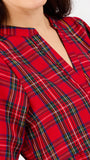 Close-up of a red tartan plaid top with a split V-neckline, worn by a model.