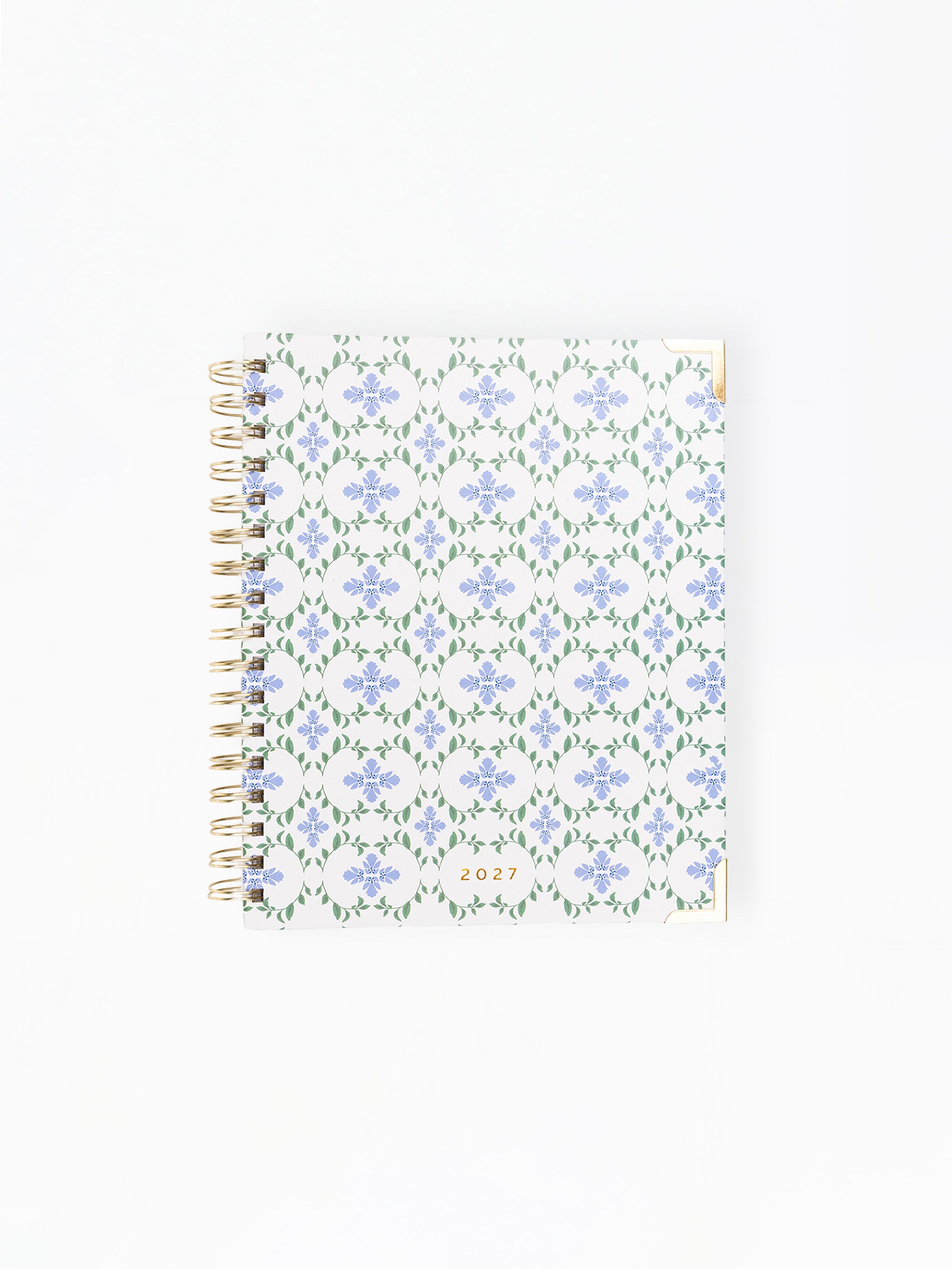 Floral patterned notebook with gold wire binding on a white background