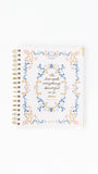 Notebook with floral design and text on a white background