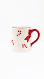 A white ceramic mug with a red handle, red rim, and red candy cane and bow details, shown on a plain white background.