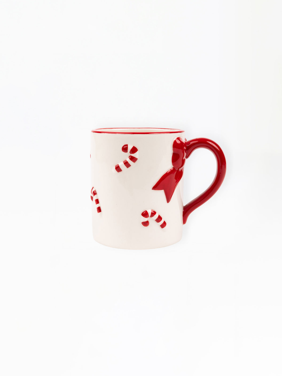 A white ceramic mug with a red handle, red rim, and red candy cane and bow details, shown on a plain white background.