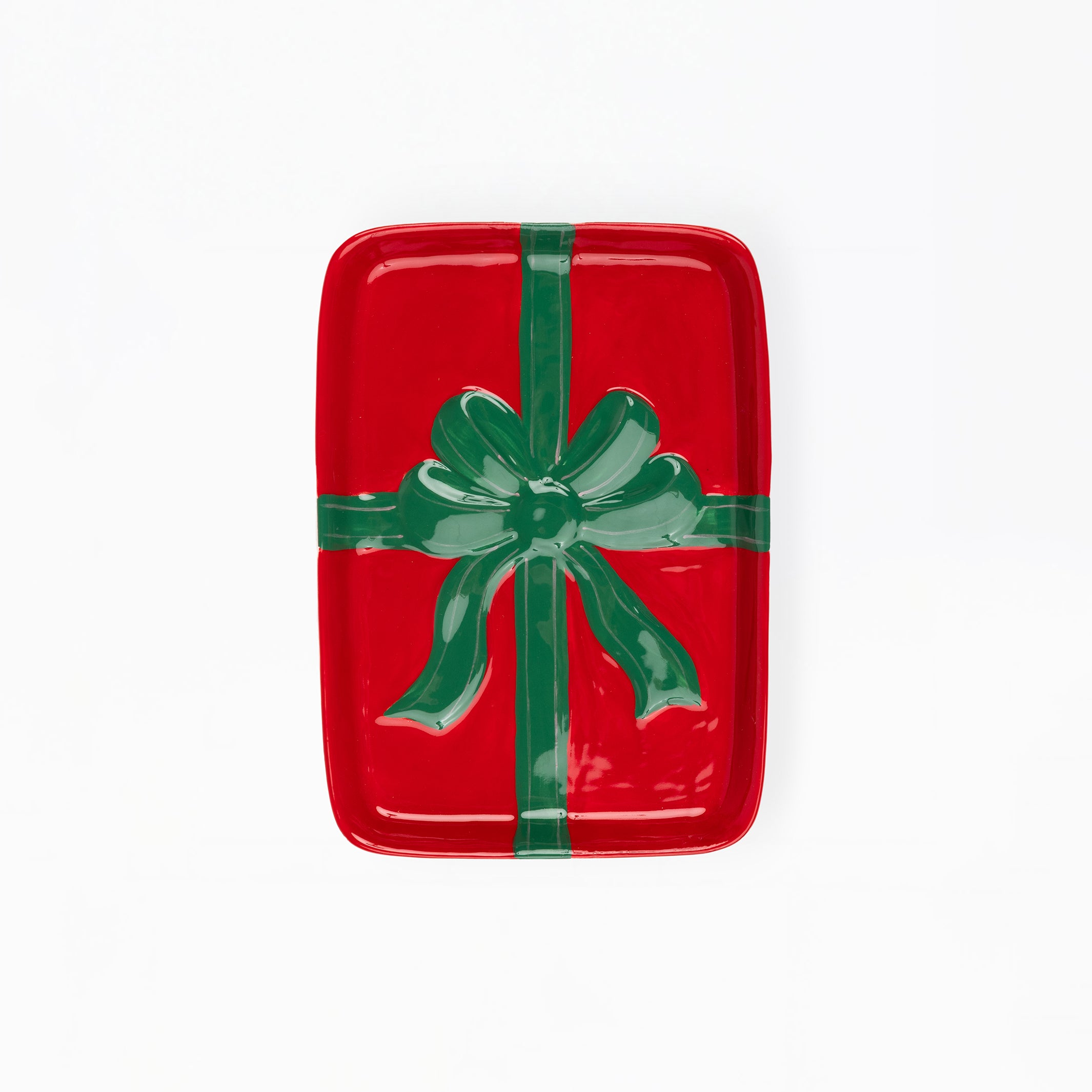 A rectangular red tray with rounded corners, decorated to look like a wrapped gift with a green ribbon and bow, shown on a plain white background.