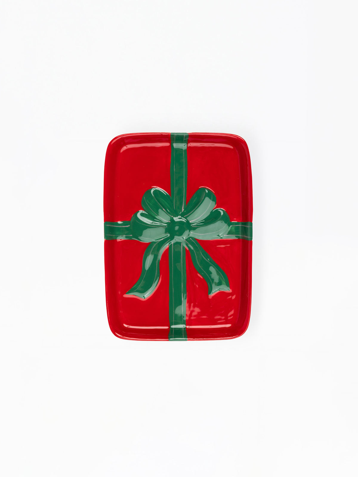 A rectangular red tray with rounded corners, decorated to look like a wrapped gift with a green ribbon and bow, shown on a plain white background.
