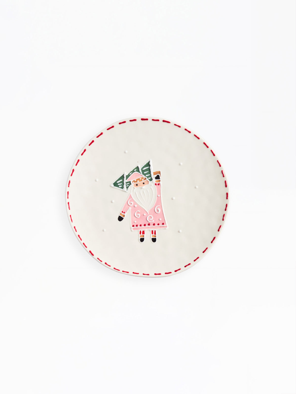 A round white ceramic plate featuring a hand-painted illustration of a Santa Claus figure holding a green Christmas tree, framed by a red dashed border on a white background.