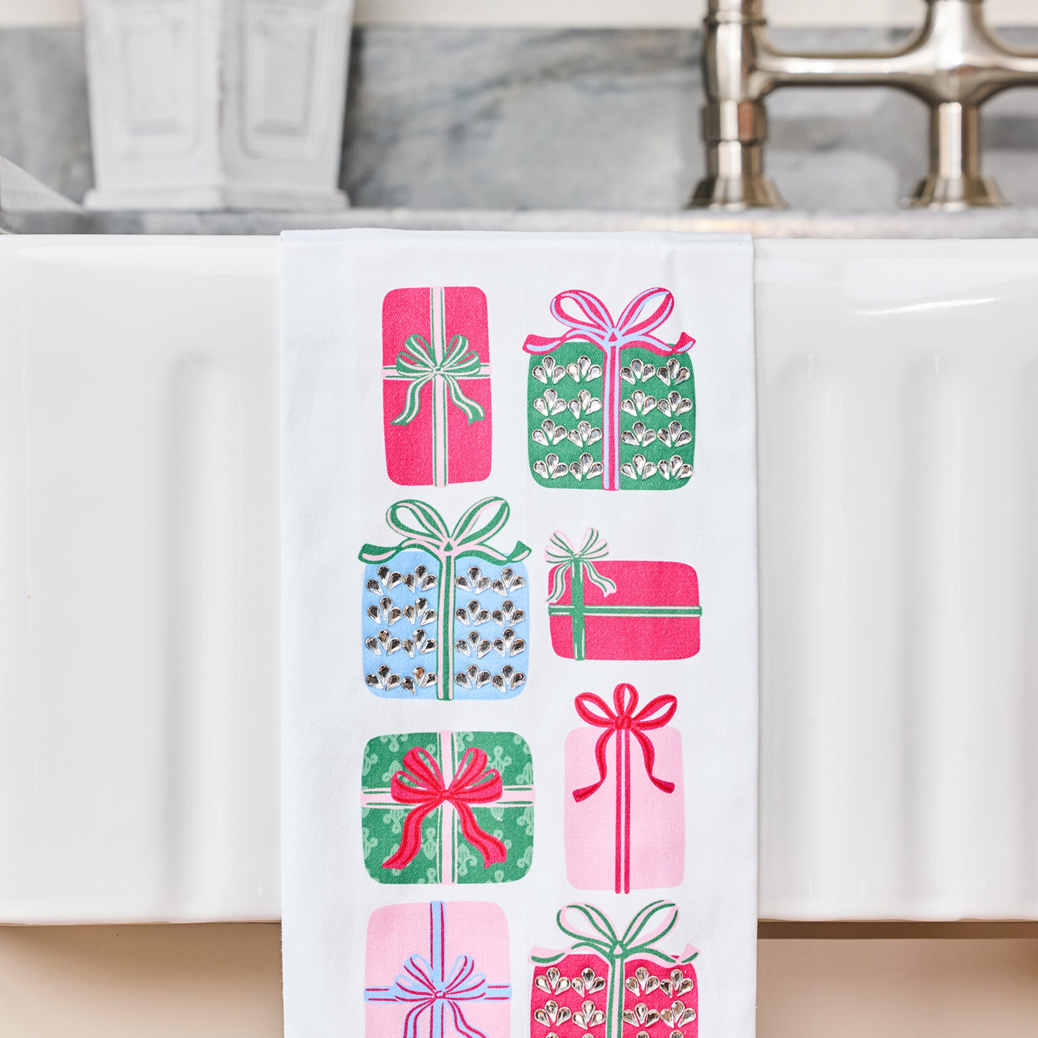 Sequin tea towel with presents on it hanging over the edge of a sink
