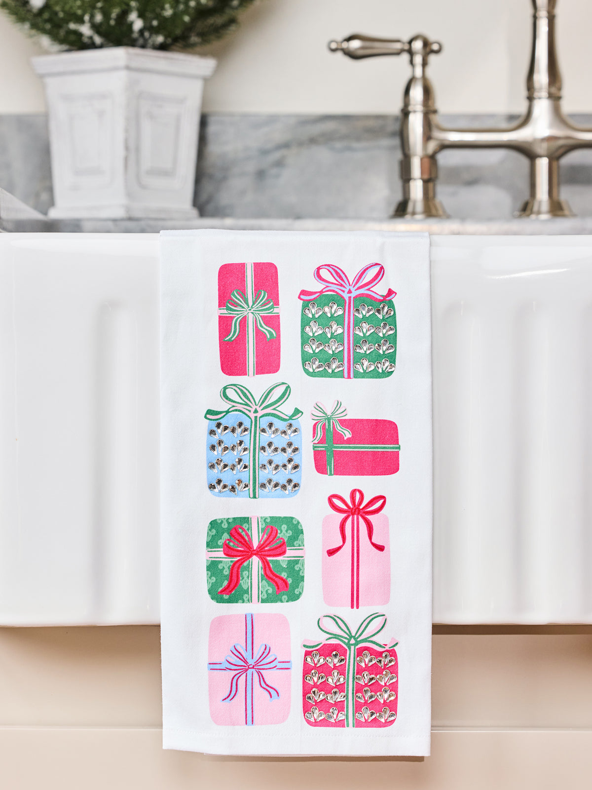 Sequin tea towel with presents on it hanging over the edge of a sink