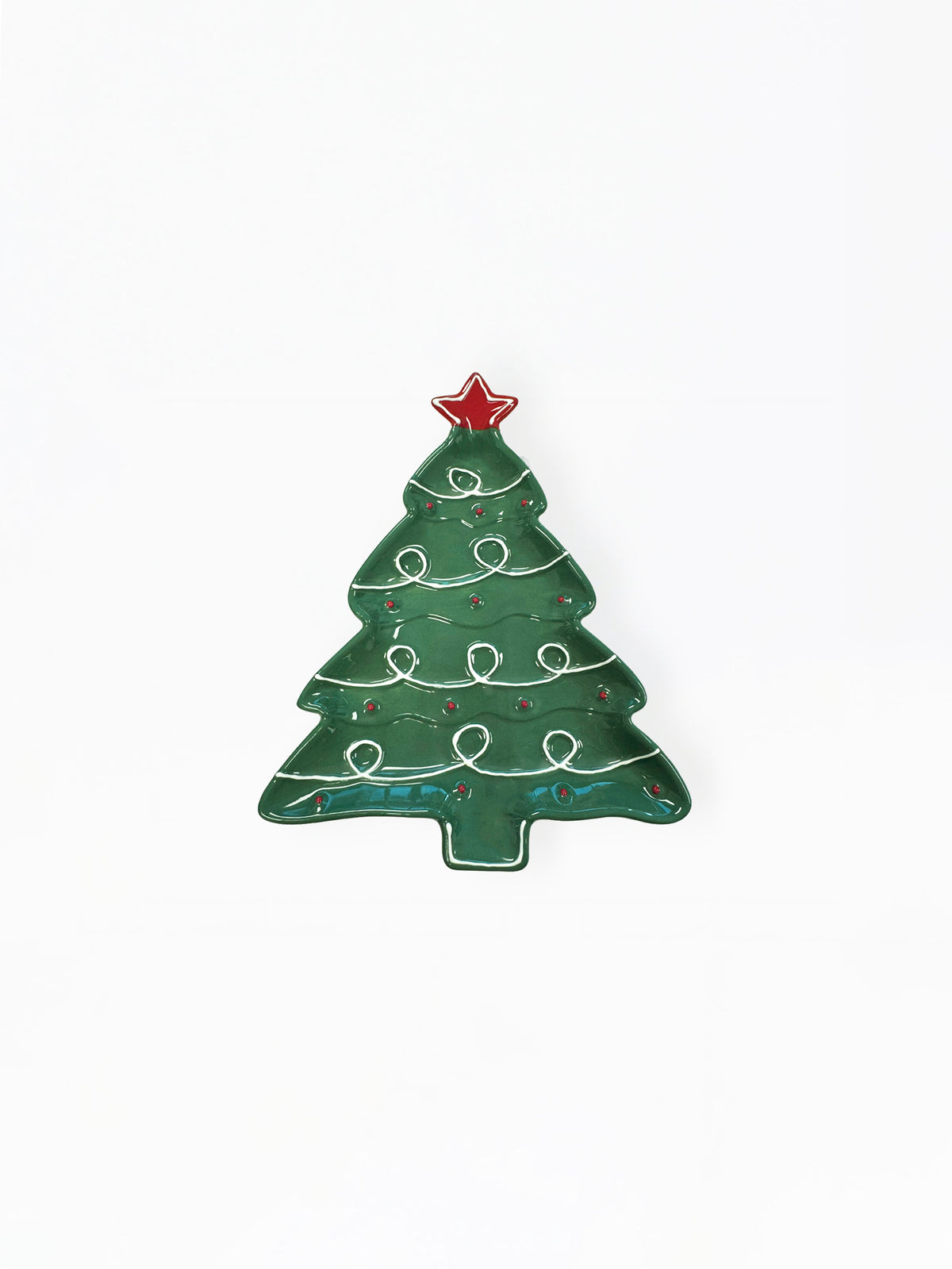 A Christmas tree shaped enamel pin in dark green with white decorative swirls, a red star topper, and small red and gold accents, shown on a plain white background.