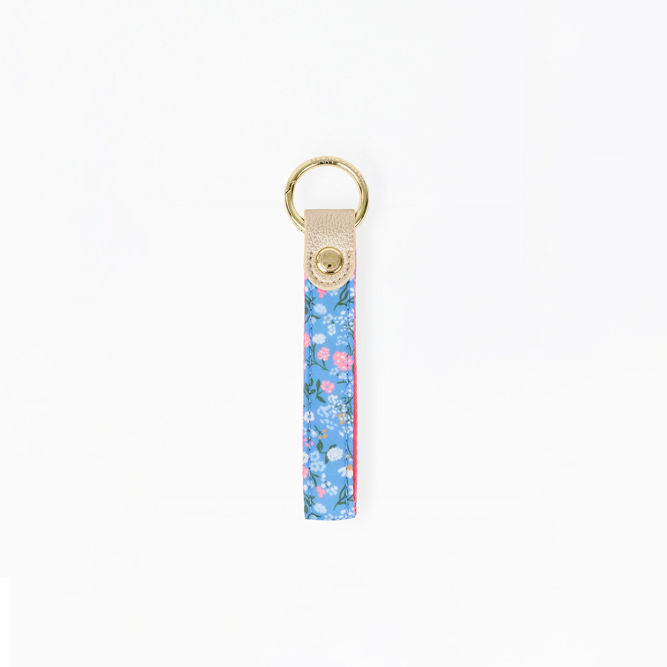 A vertical floral keychain strap with a blue, pink, and green pattern, finished with a beige leather tab and a gold-tone metal key ring.