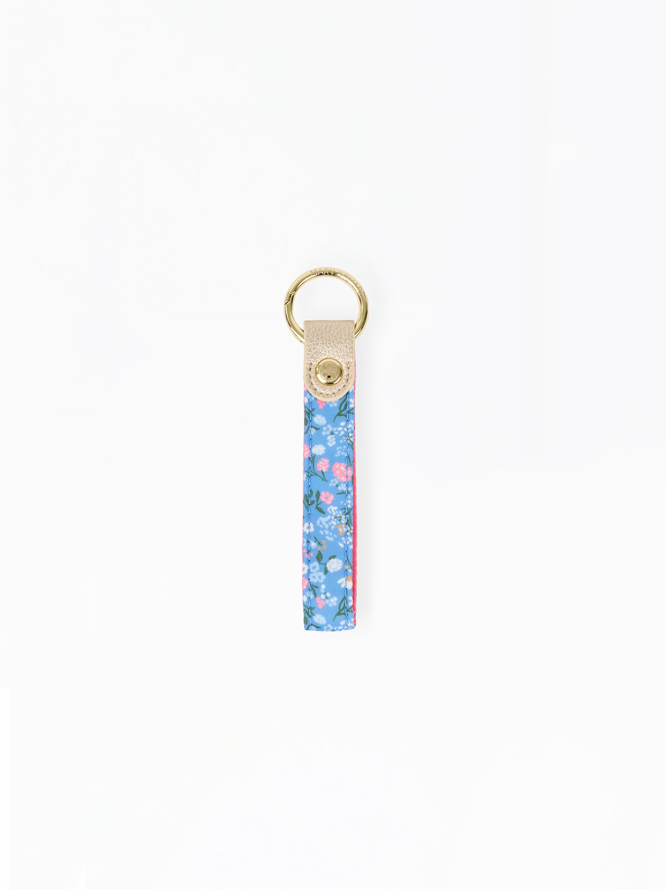 A vertical floral keychain strap with a blue, pink, and green pattern, finished with a beige leather tab and a gold-tone metal key ring.