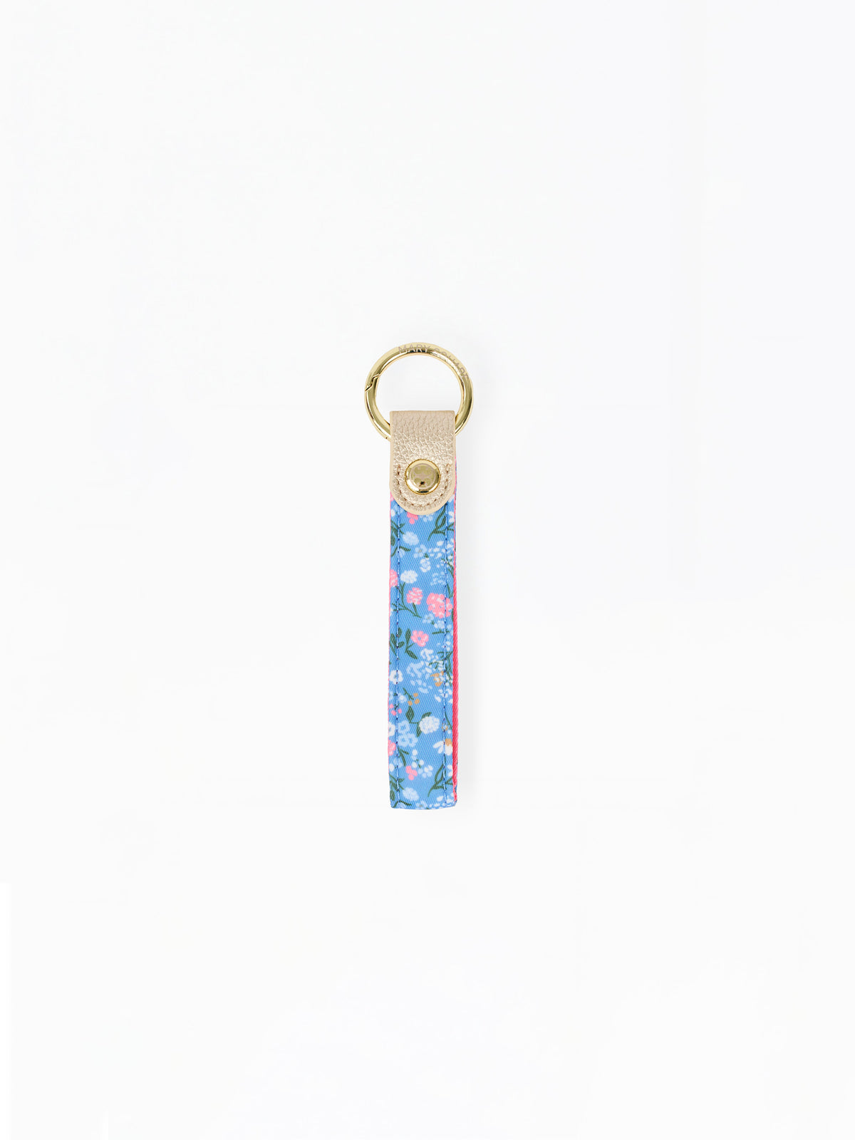 A vertical floral keychain strap with a blue, pink, and green pattern, finished with a beige leather tab and a gold-tone metal key ring.