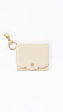 A small cream-colored leather card holder pouch with a scalloped edge and a gold-tone swan logo on the front, attached to a gold key ring and lobster clasp, shown on a plain white background.