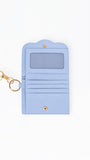 A light blue card holder wallet with a gold-tone keychain clasp, shown open on a plain white background.
