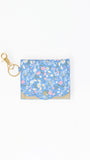 A small blue floral card holder or wallet with a gold-tone clasp and key ring, shown on a plain white background.